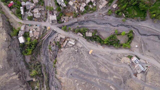 Aerial view of Diskit Monastery surrounded by rugged mountain terrain, winding roads, and a river flowing through the valley in Diskit, Ladakh, INDIA.
