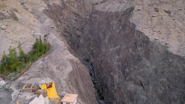 Aerial view of rocky canyon with stream and green trees in Diskit, Ladakh, India.