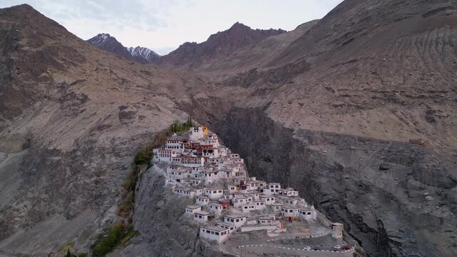 Aerial view of Diskit Monastery nestled on a rocky hillside with traditional white buildings and mountain backdrop in Diskit, Ladakh, INDIA.