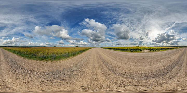 full seamless spherical hdri panorama 360 by 180 degrees angle view on gravel road near sunflowers fields in sunny summer evening in equirectangular projection, skybox VR AR virtual reality content