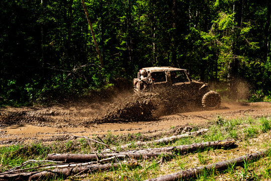 View of an off-road vehicle driving through a muddy forest track near Lake Ladoga in Sortavala, Respublika Kareliya, Russia.