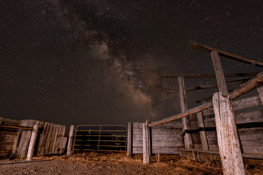 View of the old wooden corral under the brilliant Milky Way core in the night sky in Picabo, Idaho, United States.