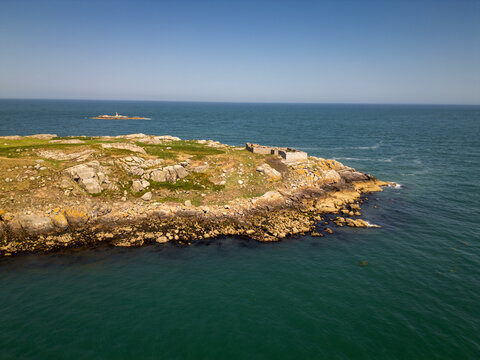 Aerial view of Dalkey Island with its rocky coastline, grassy terrain, and historic stone ruins surrounded by the blue waters of the Irish Sea in Dublin, County Dublin, Ireland.