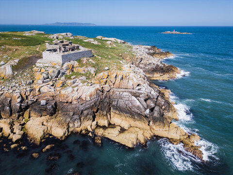 Aerial view of Dalkey Island featuring historic stone fortifications, rugged rocky coastline, and blue waters of the Irish Sea in Dublin, County Dublin, Ireland.