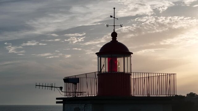 Aerial view of the Farol Museu de Santa Marta lighthouse at sunset with a dramatic sky and coastal horizon in Cascais, Lisboa, Portugal.