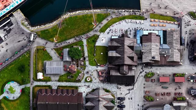 Aerial view of the waterfront area in Flam, featuring wooden buildings, paved walkways, and green spaces in Flam, Vestland, Norway.