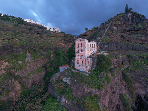 Aerial view of the historic Las Ruinas de Gordejuela industrial building perched on a dramatic cliffside overlooking the ocean in Los Realejos, Canary Islands, Spain.