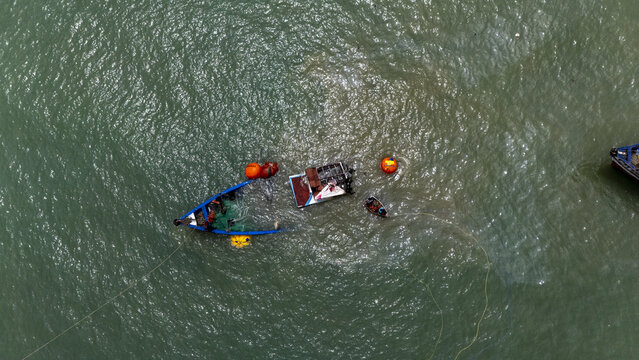 Aerial view of traditional fishing boats and nets in the sea, with fishermen working on the water Cape Coast, Central Region, Ghana.