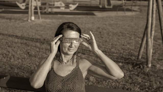 Girl witnessing solar eclipse in park with timeless black and white style