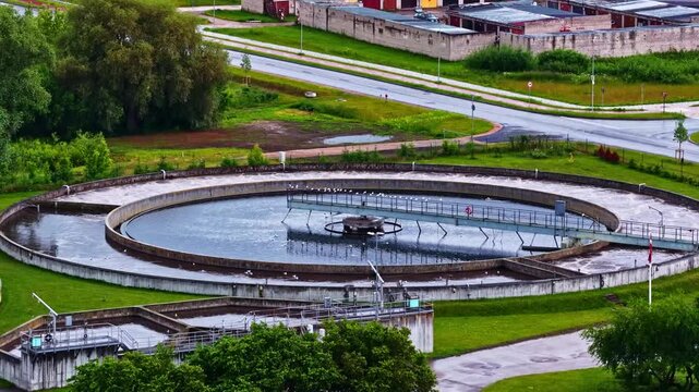 Aerial view of circular water treatment clarifier facility with industrial infrastructure surrounded by green fields and roads in Jelgava, Jelgava pilseta, Latvia.