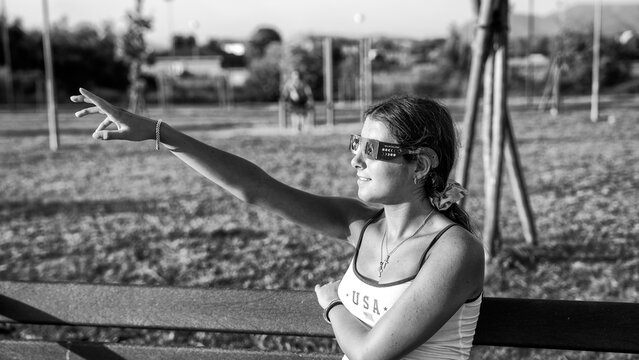Black and white image of child watching solar eclipse in natural setting