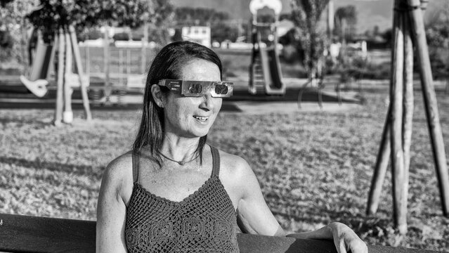 Young girl viewing solar eclipse outdoors in monochrome artistic composition