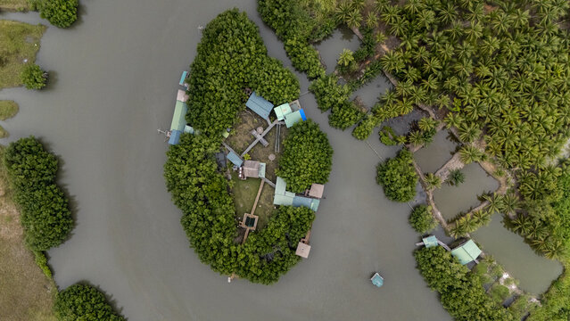 Aerial view of Gogotinkpon, a small island settlement nestled in a river surrounded by lush mangroves and palm trees in Kpomasse, Mono, Benin.