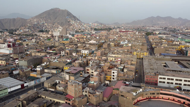 Aerial view of the Centro Historico in Lima, featuring dense historic architecture, sprawling urban rooftops, and distant hills under a hazy sky in Lima, Lima, Peru.