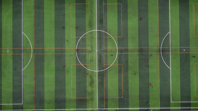 Aerial view of a soccer field with players scattered across the green pitch in La Molina, Lima Province, Peru.