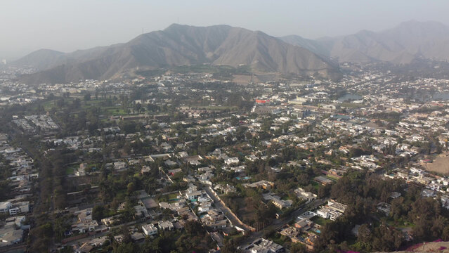 Aerial view of the residential district of La Molina with houses, lush trees, and mountains in the background in La Molina, Lima Province, Peru.