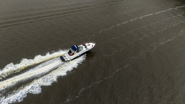 Aerial view of a motorboat cruising on the water leaving a white wake behind it in Lagos, Lagos, Nigeria.