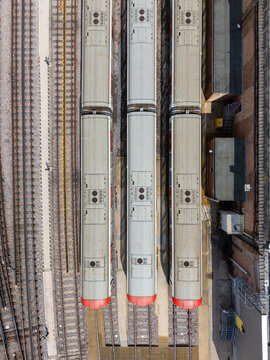 Aerial view of London Underground tube trains parked at Ealing Common Depot with parallel railway tracks and industrial depot buildings in London, England, United Kingdom.