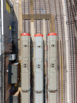 Aerial view of three London Underground tube trains parked on parallel tracks at Ealing Common Depot in London, England, United Kingdom.