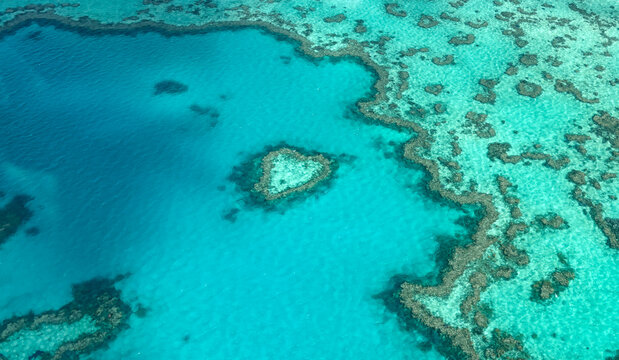 Aerial view of the iconic heart-shaped coral formation of Heart Reef surrounded by the turquoise waters of the Great Barrier Reef near Airlie Beach, Queensland, Australia.