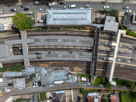 Aerial view of Acton Town Station featuring its platforms, train tracks, and surrounding urban infrastructure in London, England, United Kingdom.
