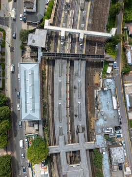 Aerial view of Acton Town Station with railway tracks, platforms, and surrounding urban infrastructure in London, England, United Kingdom.