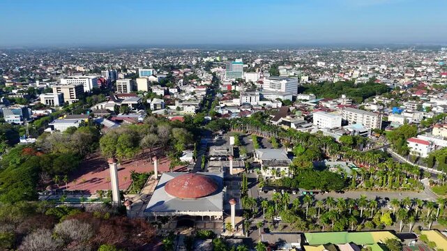 Aerial view of Masjid Raya Sabilal Muhtadin with its large dome and minarets amidst lush trees and urban sprawl in Kecamatan Banjarmasin Tengah, Kalimantan Selatan, Indonesia.