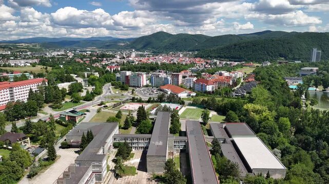 Aerial view of Gymnasium Jozefa Gregora Tajovskeho and Belveder housing estate with surrounding urban landscape and green hills in Banska Bystrica, Banskobystricky kraj, Slovakia.