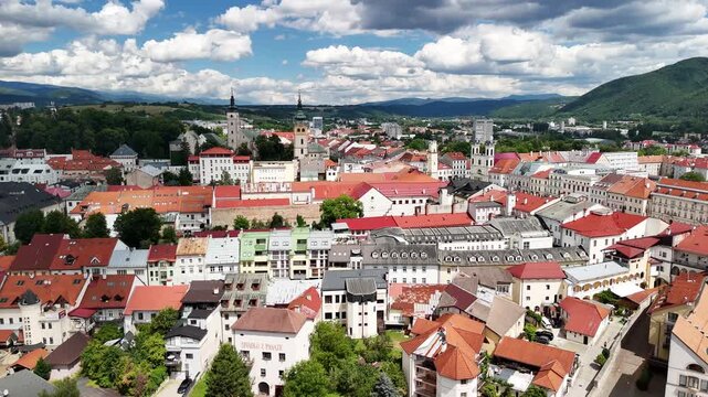 Aerial view of Namestie SNP with historic buildings, red rooftops, and surrounding hills in Banska Bystrica, Banskobystricky kraj, Slovakia.