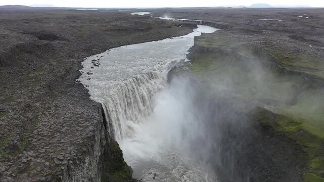 Aerial view of Dettifoss waterfall with powerful cascading water and rocky canyon walls in Selfoss, Sveitarfelagid Arborg, Iceland.