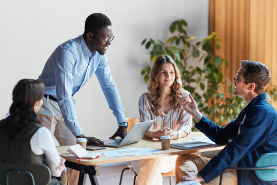 Diverse business professionals collaborating around a table. Sharing insights and working together on a project in a bright office environment