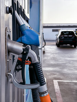 Fuel pump beside a white passenger vehicle. Closeup.