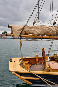 Sonderborg, Denmark - 07 July 2026: View of historic sailing ship fishing logger HF 42 from Germany docked at the quay with wooden deck, rigging, and a ship wheel under a cloudy sky.