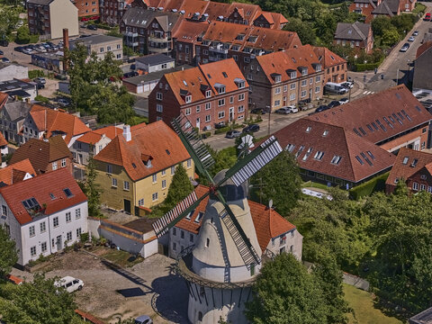 Sonderborg, Syddanmark, Denmark - 09 July 2026: Aerial view of Slotsmollen windmill surrounded by historic red-roofed buildings and lush greenery in the town center.