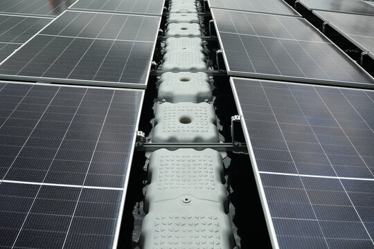 Aerial view of floating solar panels installed on water with modular plastic pontoons in Berau Regency, East Kalimantan, Indonesia.