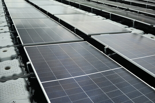 Aerial view of floating solar panels installed on a water reservoir, showcasing renewable energy infrastructure in Berau Regency, East Kalimantan, Indonesia.