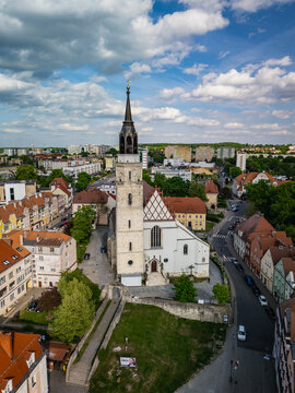 Boleslawiec, Poland - 11 May 2025: Aerial view of the Basilica of the Assumption of the Blessed Virgin Mary and Saint Nicholas surrounded by historic town buildings and red-tiled rooftops.