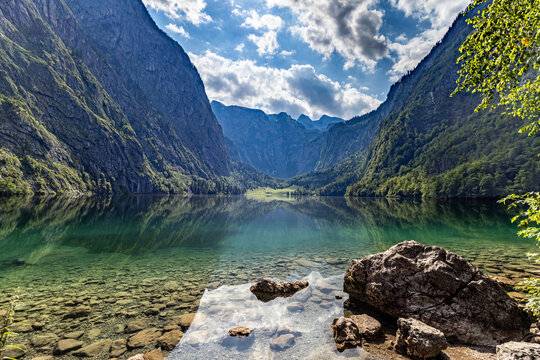 View of Konigssee featuring crystal clear water, rocky shoreline, and steep mountains Schonau am Konigssee, Bavaria, Germany.