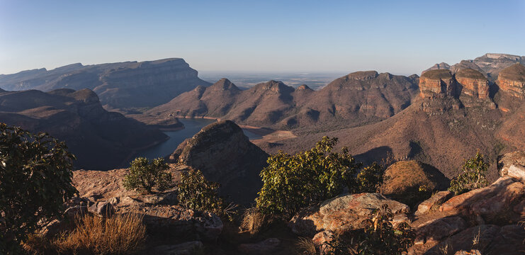 View of the Blyde River Canyon featuring dramatic rocky cliffs, a winding river, and rugged landscape in South Africa.