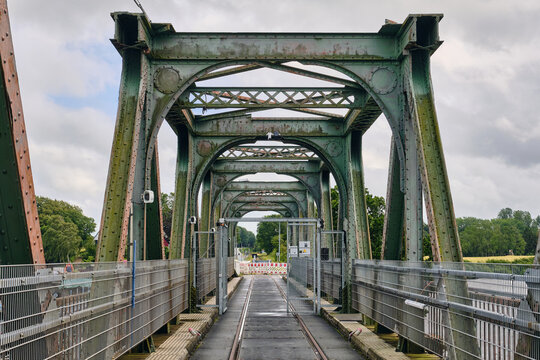 Rieseby, Germany - 02 July 2026: View of the Lindaunisbrucke during renovation works, featuring a temporary footbridge installed on the historic railway bridge structure under a cloudy sky.