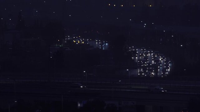 Aerial view of highway traffic at night with glowing car headlights and taillights moving along the road in Algeria.