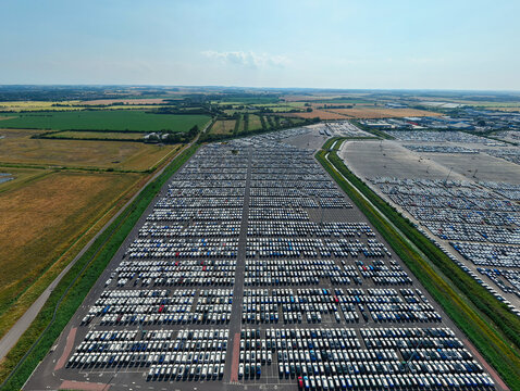 Aerial view of the BCA Kia car distribution service in Stallingborough, with thousands of new vehicles parked in rows across a vast lot. Stallingborough, England, United Kingdom.