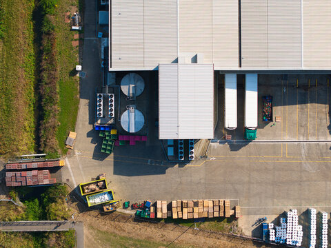 Aerial view of a large industrial warehouse facility with loading docks, parked trucks, storage containers, and pallets in Grimsby, England, United Kingdom.