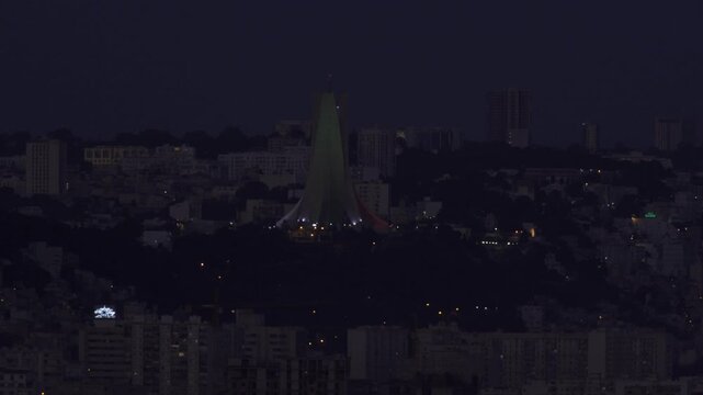 Aerial view of the illuminated Martyrs' Memorial standing prominently over the city of Algiers at night in Algeria.