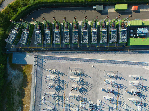 Aerial view of an electrical substation and a row of containerized industrial generator compressor units in Immingham, England, United Kingdom.