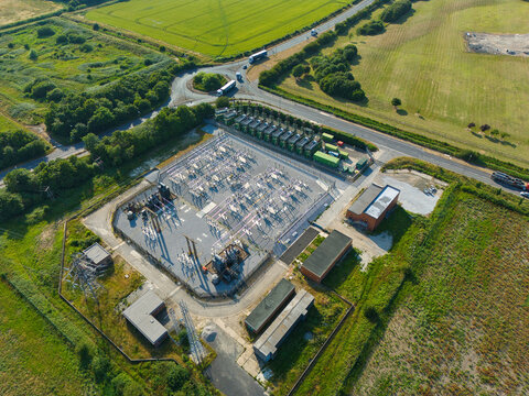 Aerial view of an electrical substation with containerized industrial generator compressor units situated in a rural landscape near Immingham, England, United Kingdom.