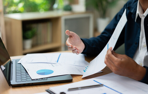 Business Professional Reviewing Financial Report and Business Performance Analysis with Laptop in Modern Office.