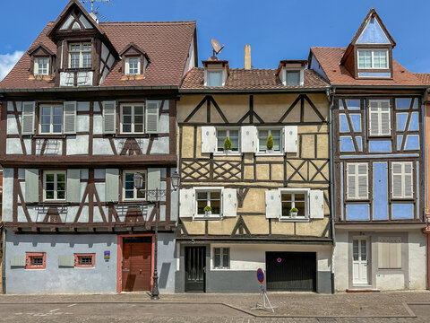 View of traditional half-timbered houses with colorful facades and wooden shutters in the historic town of Colmar, Grand Est, France.