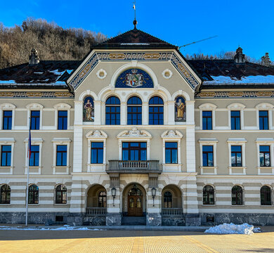 View of the historic Government Building with its ornate facade and central coat of arms under a clear blue sky in Vaduz, Liechtenstein.