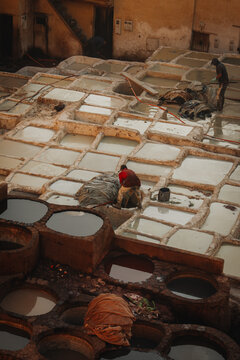 Fes, Fez-Meknes, Morocco - 11 November 2025: View of workers processing leather in the stone vats of the historic Chouara Tannery.